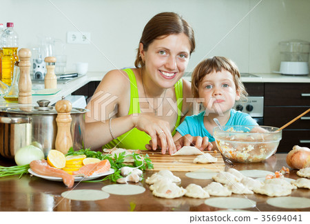mother and her little daughter doing Fish dumplings in a home kitchen mother and her little daughter doing Fish dumplings in a home kitchen 35694041
