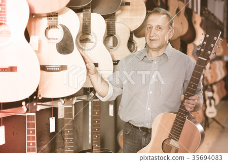 male is standing with modern guitar 35694083