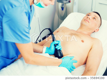 Female doctor is doing vacuum massage procedure for anti-fat to patient 35694100