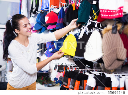 Woman choosing new knit cap 35694246