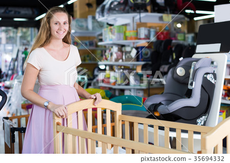 pregnant woman buying baby crib pregnant woman buying baby crib 35694332