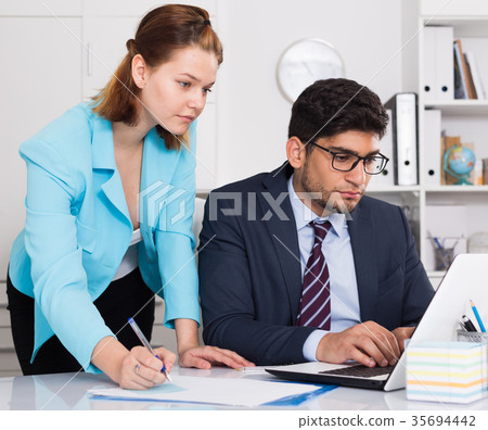 Businessman and businesswoman working together 35694442