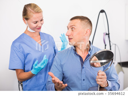 Client is examining result of procedure in mirror Client is examining result of procedure in mirror 35694612