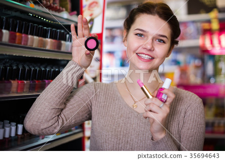 Young female customer looking for make-up items 35694643