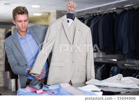 Adult male selling jacket in the store Adult male selling jacket in the store 35694906