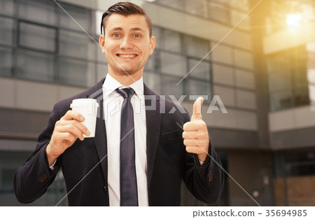 Office worker is drinking coffee outdoors Office worker is drinking coffee outdoors 35694985