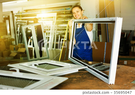 woman using measuring tape in her work in production of pvc wind woman using measuring tape in her work in production of pvc wind 35695047