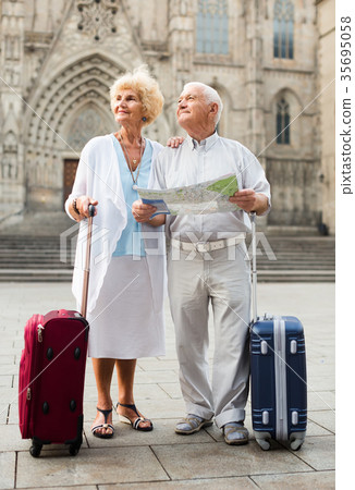 Senior woman and man traveling together looking for destination with city map Senior woman and man traveling together looking for destination with city map 35695058
