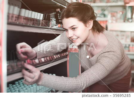 female customer looking for nail polish in cosmetics shop female customer looking for nail polish in cosmetics shop 35695285