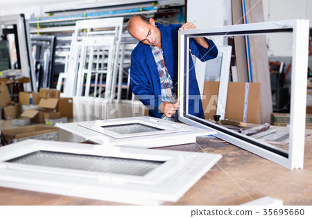 Foreman with clipboard in hands checking quality of finished PVC windows 35695660