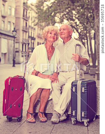 Portrait of senior couple of tourists resting on stone bench Portrait of senior couple of tourists resting on stone bench 35695718