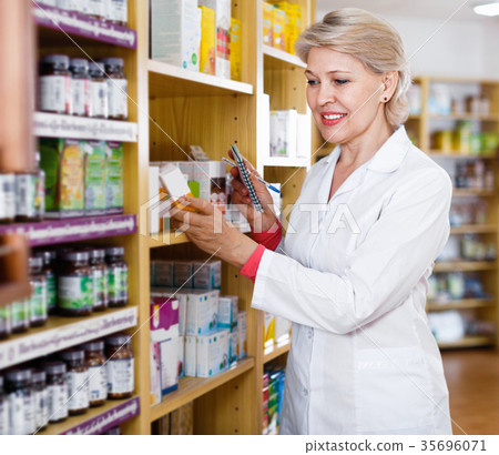 Mature female seller suggesting useful skin care products 35696071