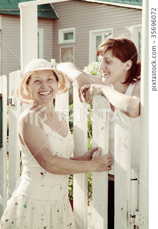 happy women near fence wicket 35696072