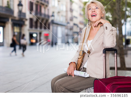 Mature female tourist is sitting with map Mature female tourist is sitting with map 35696185