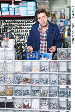 worker in hardware store trading goods for water tap in uniform 35696210