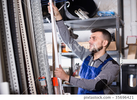 Charming man worker deciding on plastic trim corners 35696421