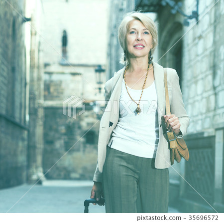 Mature woman tourist is walking in classic dress Mature woman tourist is walking in classic dress 35696572