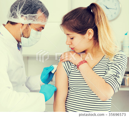 Doctor vaccinating teenage patient 35696573