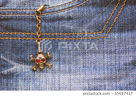 Skull brooch on torn jeans . 35697417
