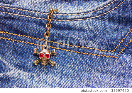 Skull brooch on torn jeans . 35697420