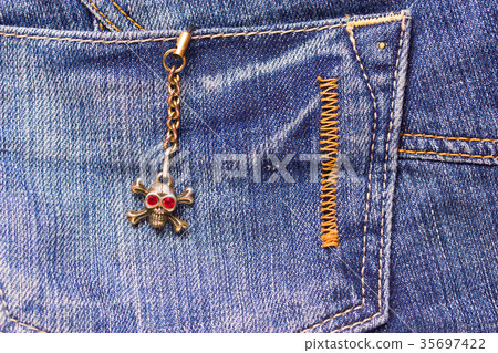 Skull brooch on torn jeans . Skull brooch on torn jeans . 35697422