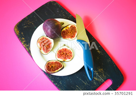 Fresh sweet ripe figs on dark wooden board  35701291