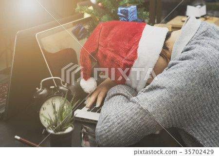 woman with santa hat sleeping on desk office 35702429