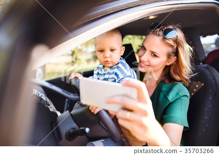 Young mother with smartphone and baby boy in the Young mother with smartphone and baby boy in the 35703266