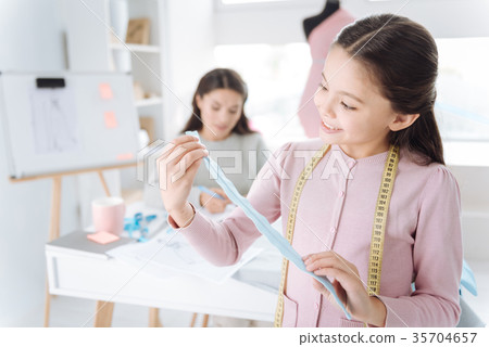 Delighted pretty girl looking at the zip fastener 35704657