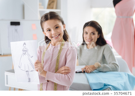 Joyful smart girl showing her design sketch 35704671