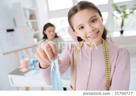 Happy cute girl wearing a tape measure 35704727