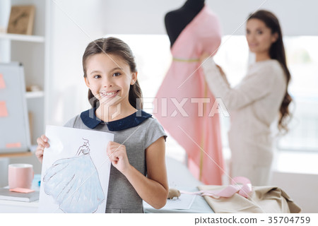 Joyful creative girl holding her drawing 35704759