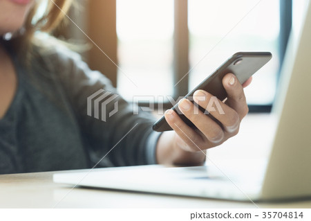 woman use phone on desk in office place 35704814