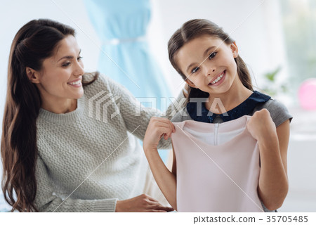Delighted cute girl holding a new dress Delighted cute girl holding a new dress 35705485