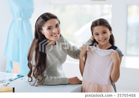 Cheerful young girl holding her dress Cheerful young girl holding her dress 35705488