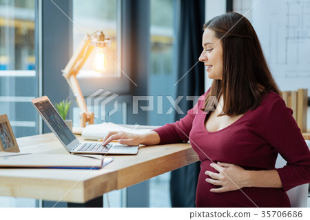 Concentrated pregnant woman with a laptop Concentrated pregnant woman with a laptop 35706686