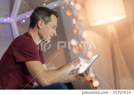 Attentive man playing with tablet Attentive man playing with tablet 35707614