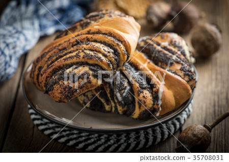 Sweet buns with poppy seed and frosting. 35708031