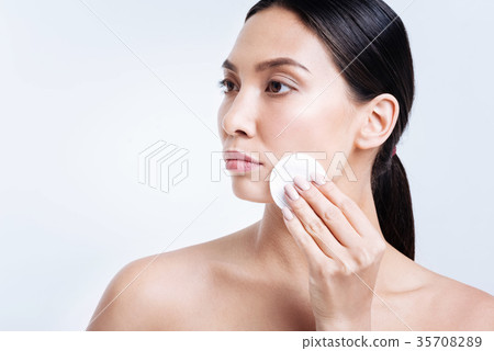 Gorgeous woman removing makeup with cotton pad Gorgeous woman removing makeup with cotton pad 35708289