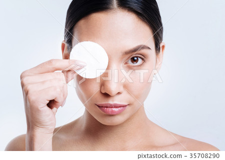 Close up of charming brunette covering eye with 35708290