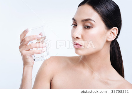 Dark-haired woman holding a glass of water 35708351