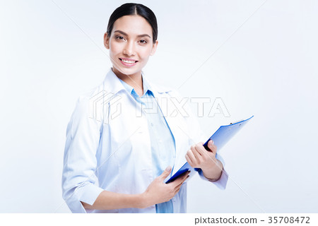 Pretty doctor holding blue sheet holder and 35708472
