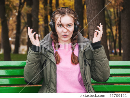 Surprised young girl with headphones Surprised young girl with headphones 35709131
