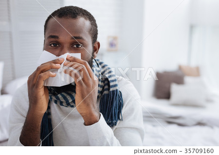 Calm ill man using soft handkerchief at home 35709160