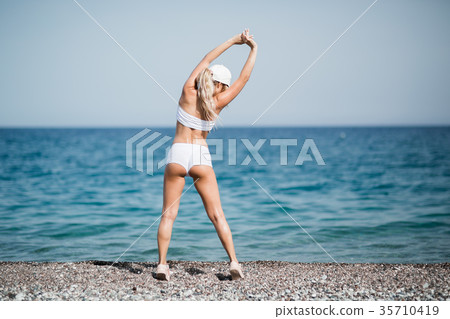 back view of sporty woman doing stretching back view of sporty woman doing stretching 35710419