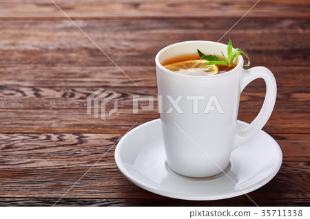 Tea with lemon in white cup, cinnamon sticks 35711338