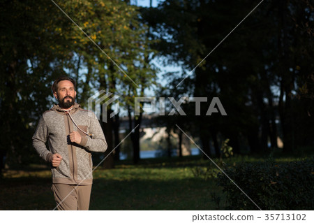 Beardy mid aged man running in nature. 35713102