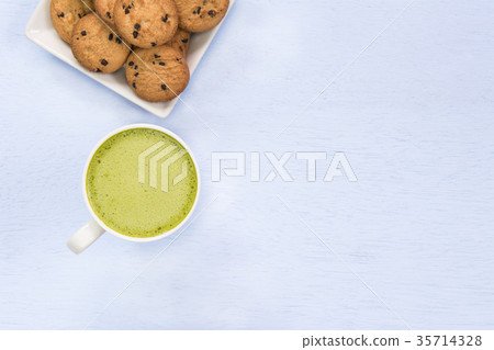 cup of hot matcha latte and butter cookie  35714328