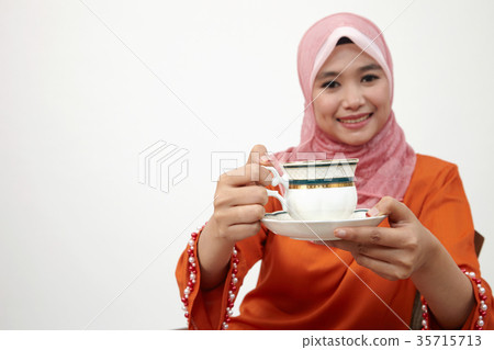 malay girl with tudung holding cup of hot tea 35715713