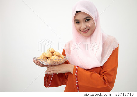 malay girl with tudung with kueh bahulu 35715716